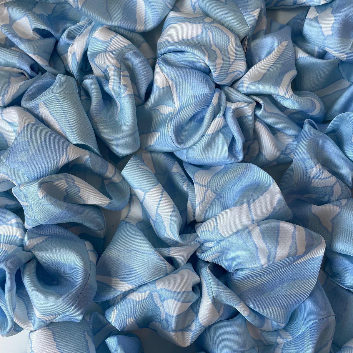 Multiple blue waterlily print scrunchies shown together